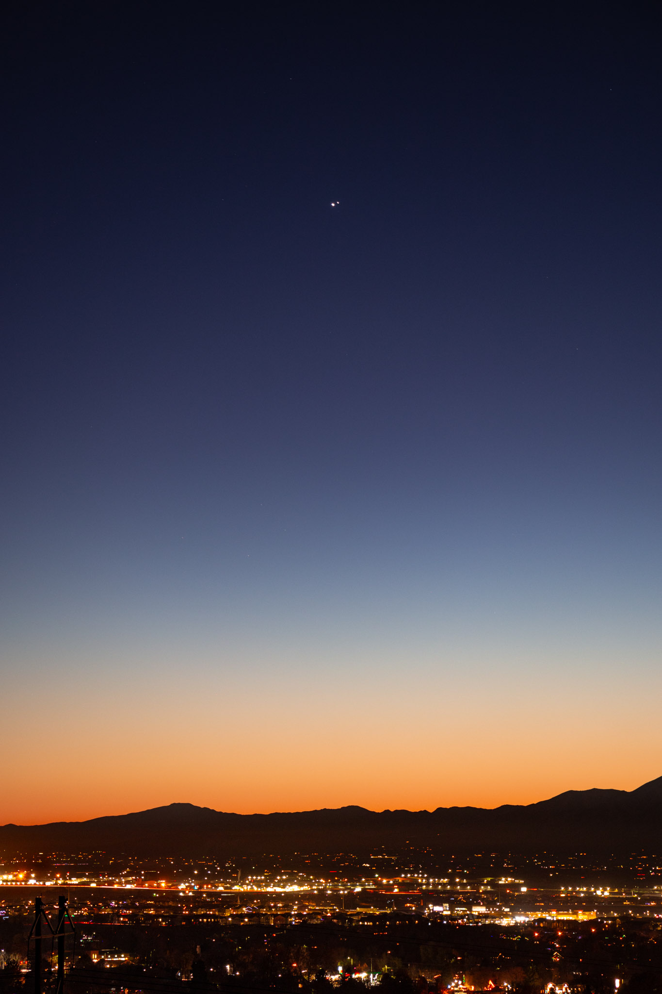 jupiter and venus so close to each other above city lights after sunset